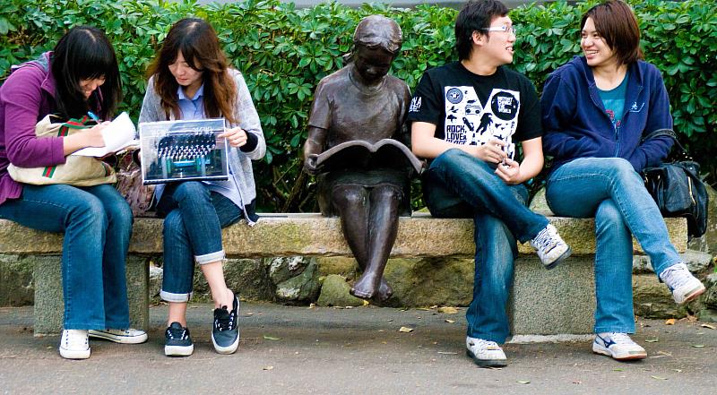 淡江大學「讀書樂」系列雕像之淡水校園「閱讀的女孩」,一直吸引學生們與之合影。(圖/淡江大學提供)