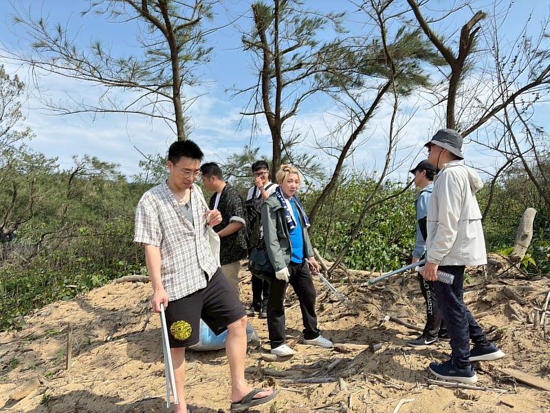 夥伴手持夾子與垃圾袋,撿拾塑膠瓶、廢棄漁網、寶特瓶及吸管,開心淨灘。(靈鷲山佛教教團提供)