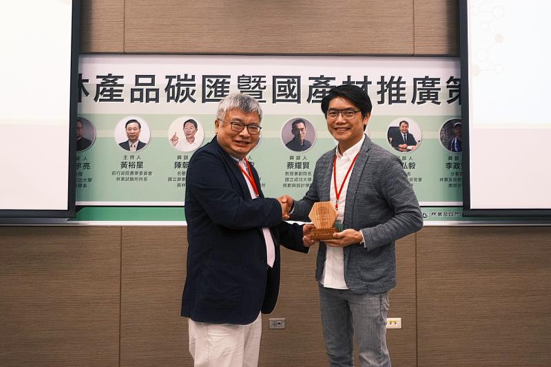 王升陽教授(左)頒贈國產柳杉木獎牌給木匠兄妹的周信宏總經理