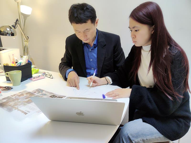 亞大商設系龍希文老師 (左),指導商設系黃品瑜同學修正設計作品。