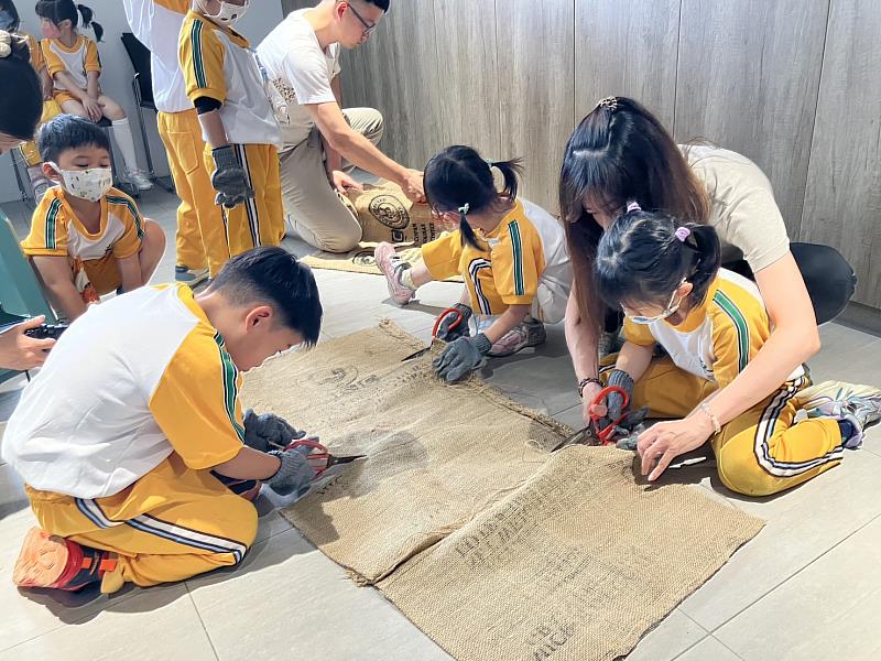 師生一起小心的用剪刀將麻布袋裁成小塊備用