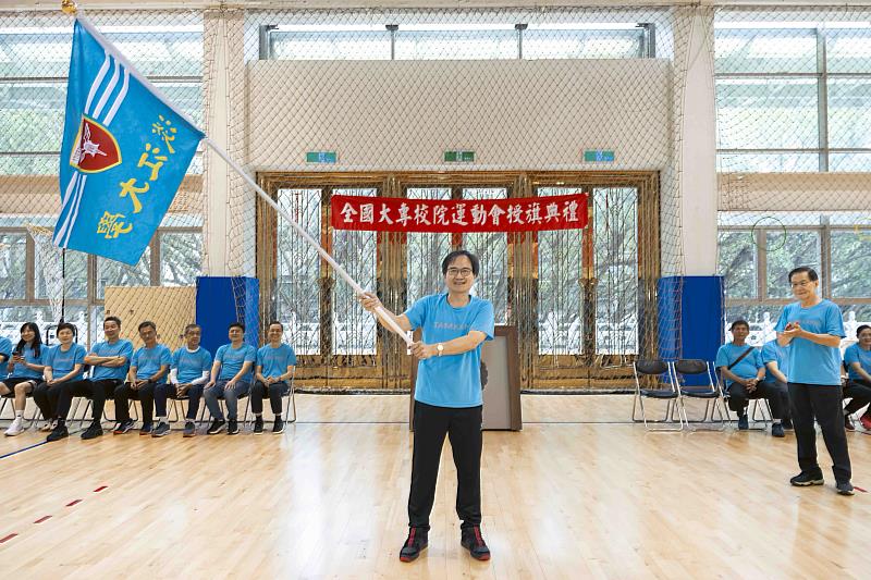 114年全大運授旗典禮中,陳逸政體育長揮舞校旗展現士氣,葛煥昭校長(右)鼓掌加油。(圖/淡江大學提供)