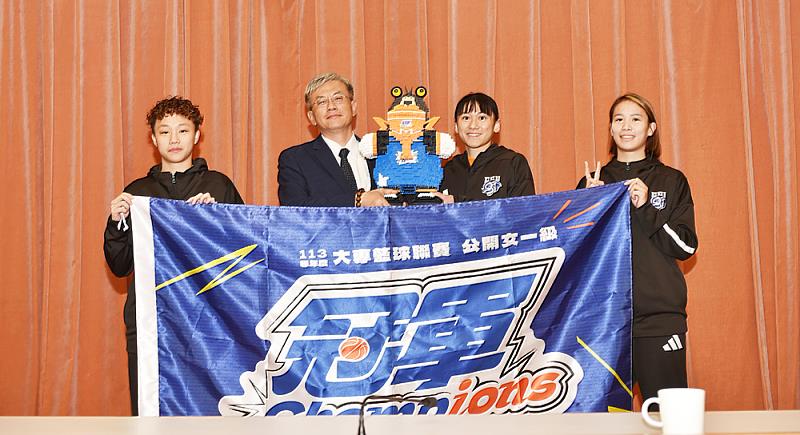女籃隊長鄭慧慈(右二)代表球隊，將象徵勝利與榮耀的冠軍吉祥物熊獻給學校由副校長王志誠代表接受。右一為得分后王玥媞。