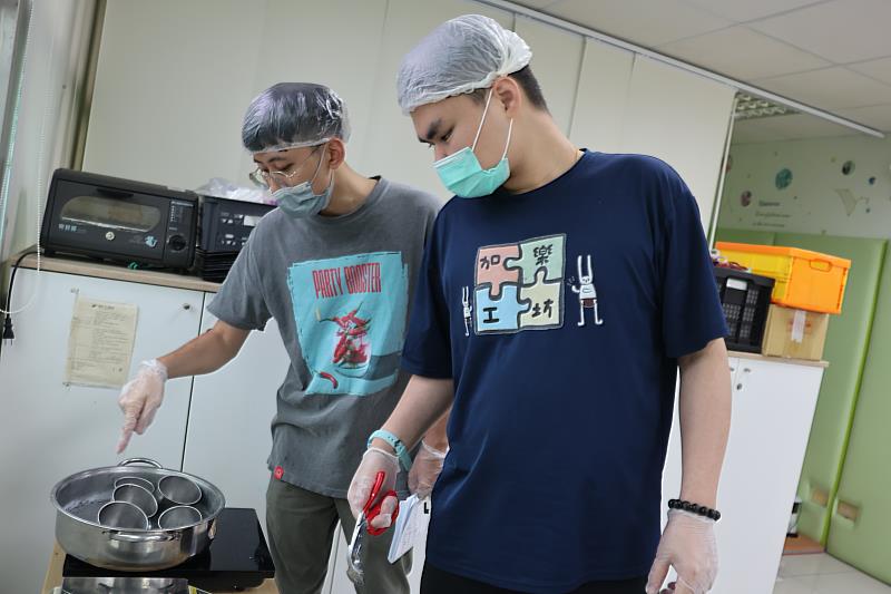 在伊甸教保老師周劭邦(左)的陪伴下，阿辰(右)逐漸克服專注力不足的情形，認真的記下製作手工肥皂的步驟。