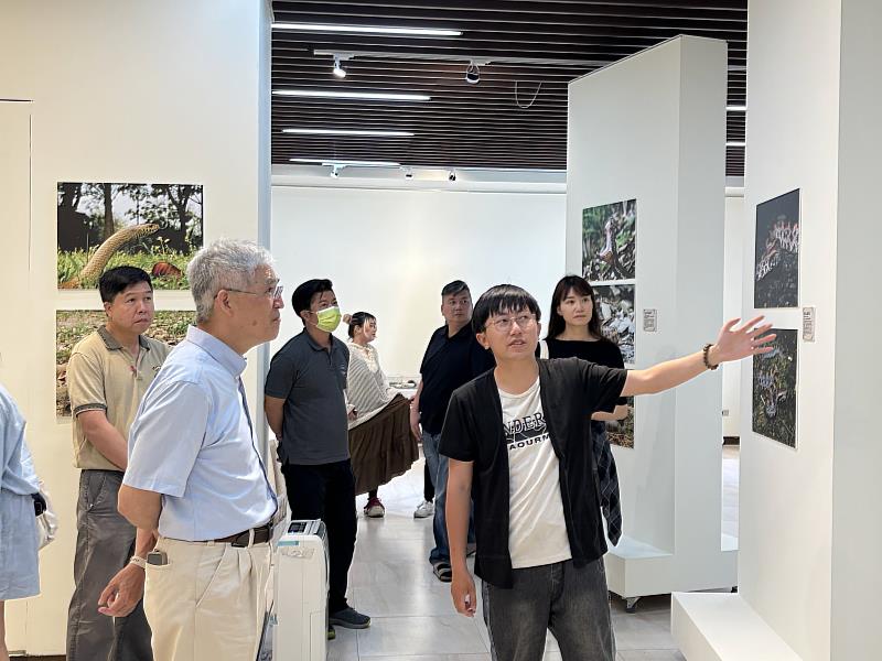 南華大學舉辦蛇來運轉攝影特展，特展發起人就讀自然與生物科技學系四年級的黃羿勳向校長及參觀者介紹攝影作品。
