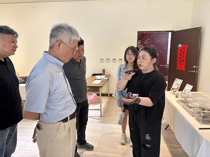 南華大學舉辦蛇來運轉攝影特展，就讀傳播系二年級的林建廷向高俊雄校長介紹活體蛇類並進行互動。