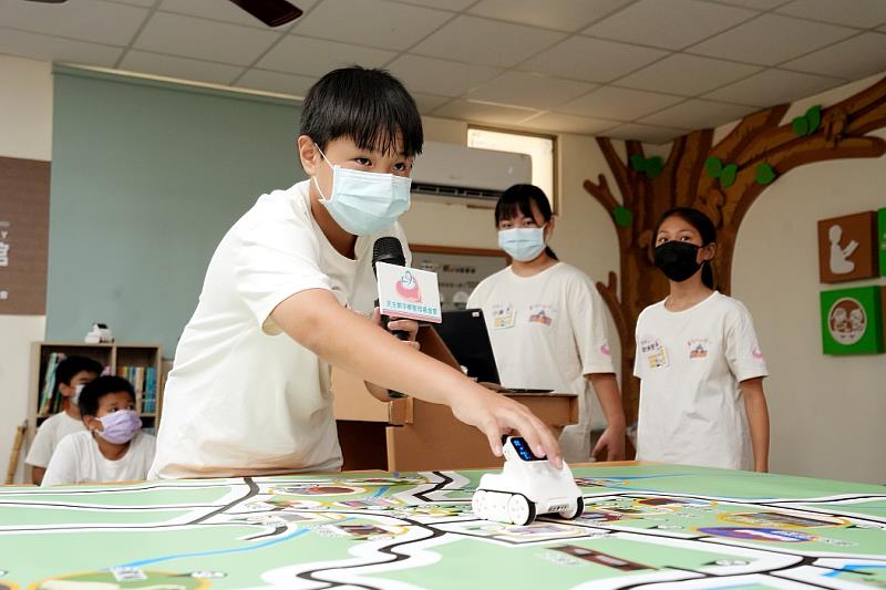 孩子操作機器人在親手繪製的社區地圖上行走