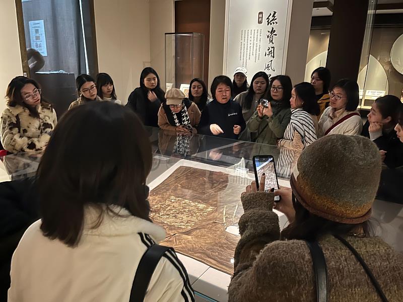 亞大時尚系同學參觀蘇州絲綢博物館，導覽員解說蠶絲服飾、刺繡文物展覽。