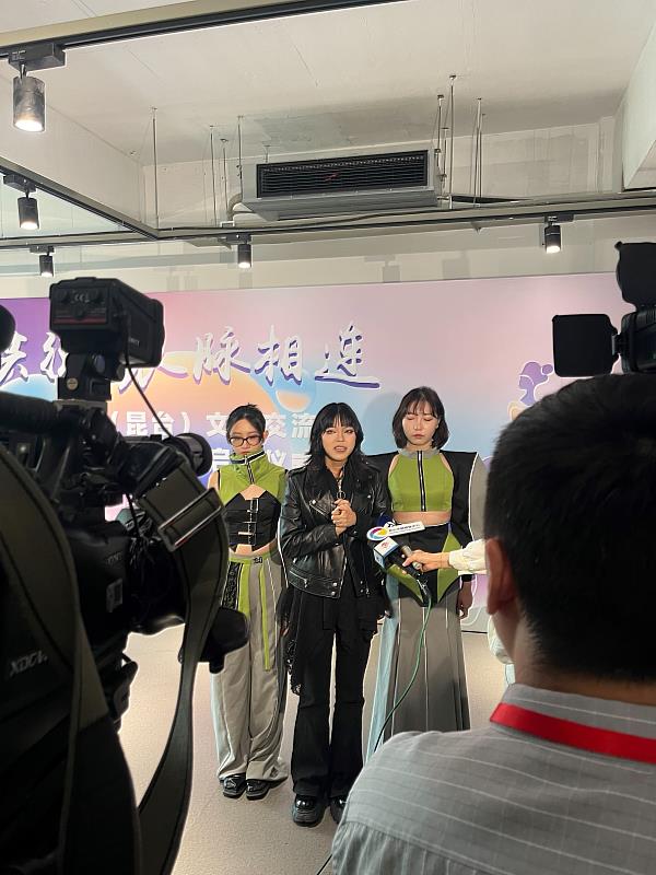 亞大時尚系夏致琳同學(中)受訪，闡述自己作品設計理念。