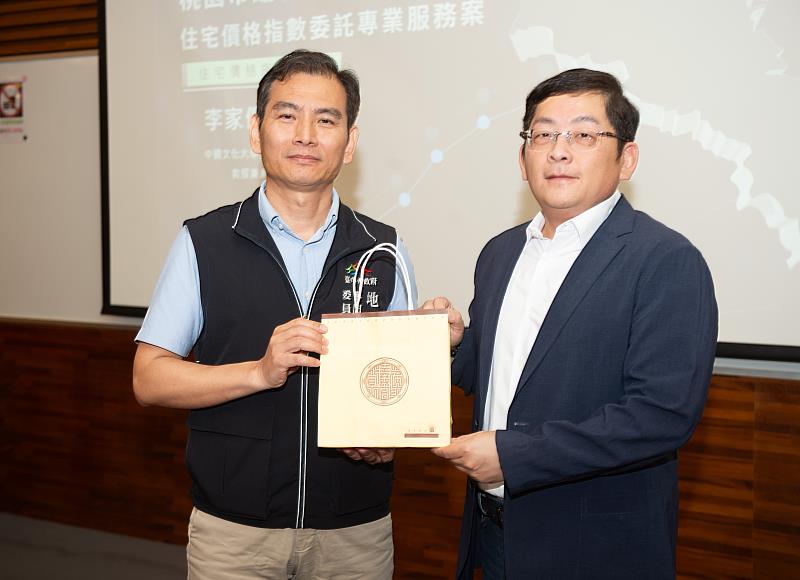 台中市地政局吳志偉主任贈送禮物予李家儂教授(右)。
