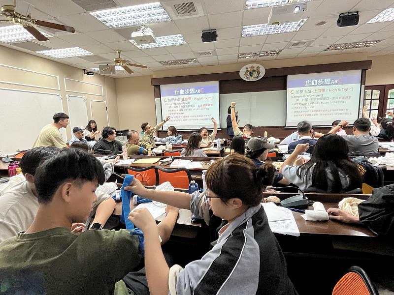 南華大學舉辦防災士訓練，學員互相練習操作急救止血帶。