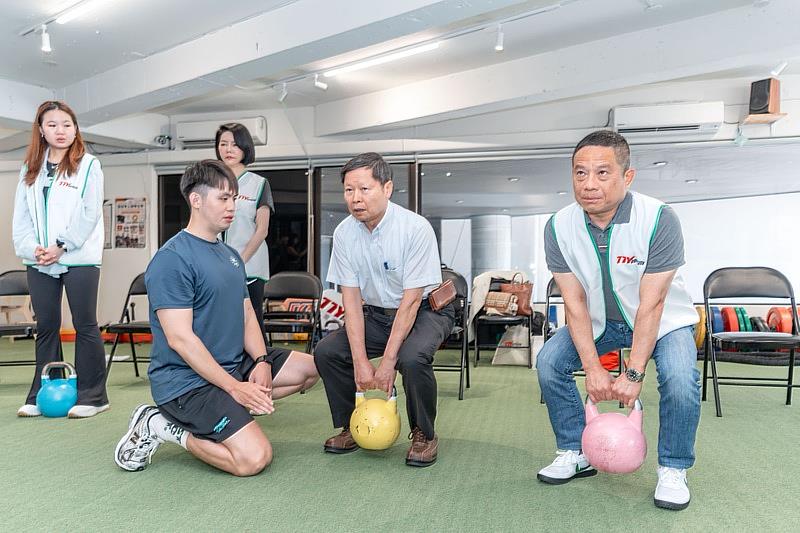 感染症醫學會理事長張峰義(右二)示範抓舉壺鈴。