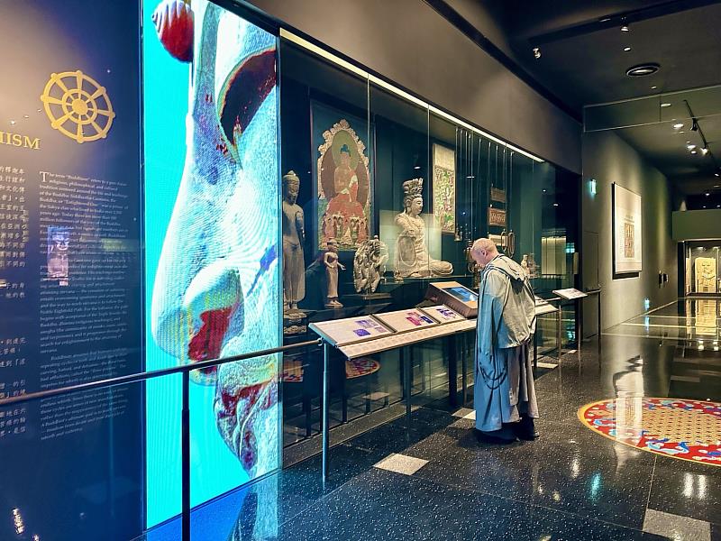 台南菁寮聖十字架天主堂本堂神父呂天恩，欣賞世界宗教展示大廳裡的文物。（圖由世界宗教博物館提供）