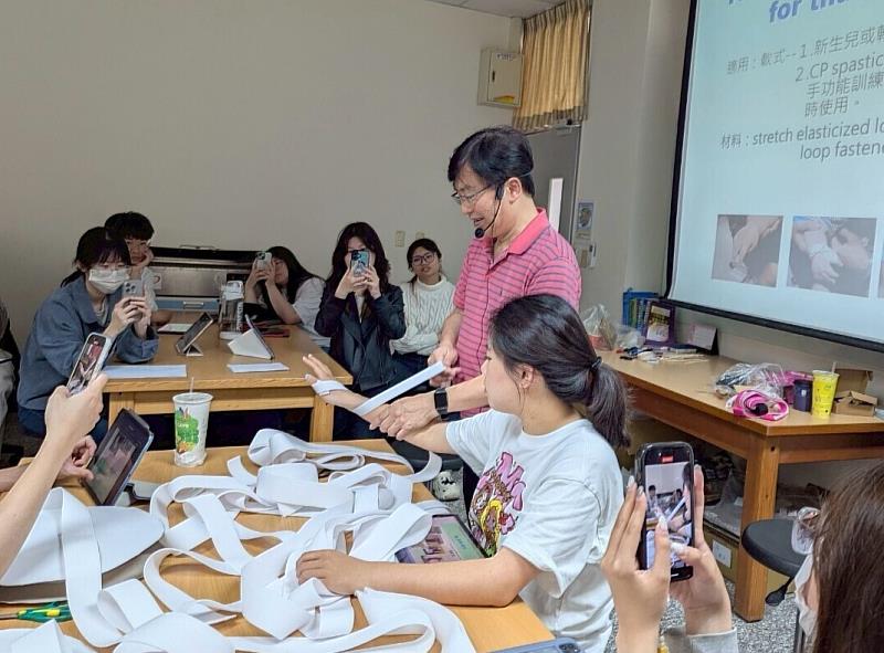 張瑞昆老師(站立者)教導同學利用彈性繃帶、黏扣帶，製作矯正肢體位置的束帶。