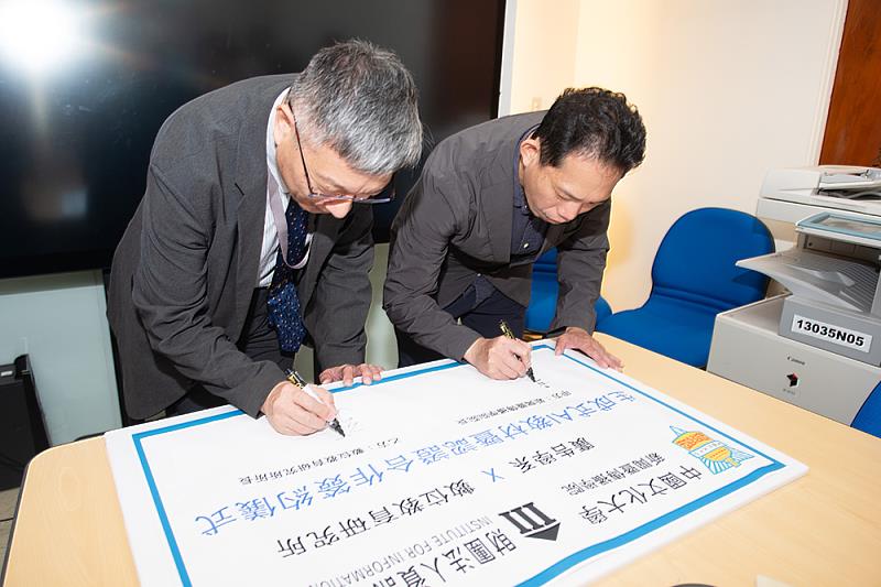 新傳學院郭文平院長與資策會教研所所長張育誠簽署合約。