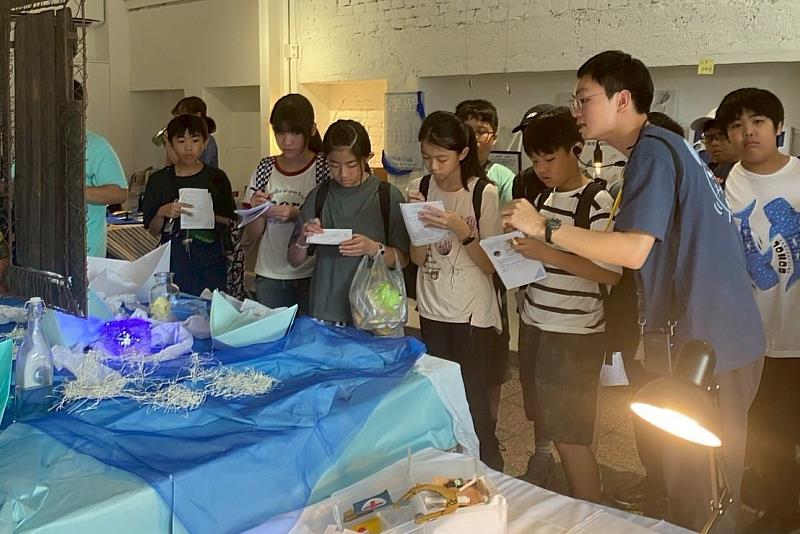 南大語應組同學黃茌翰向安定國小學童介紹室內展區「浮光」