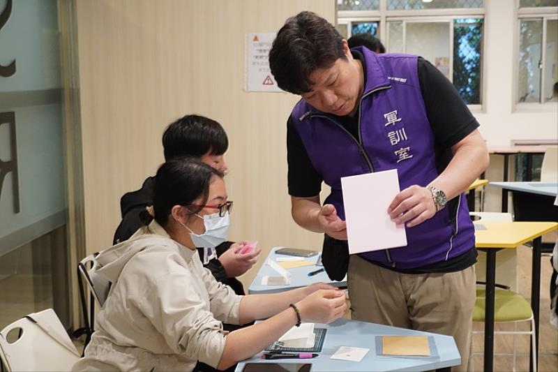 圖／軍訓室每年協助學子舉辦多元活動提升五育學習；教官劉德慶細心說明卡片製作方式。