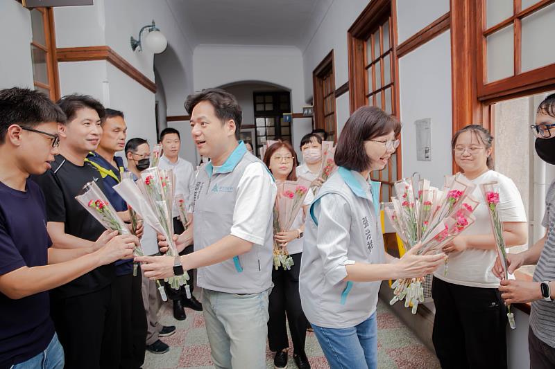 邱臣遠代理市長與秘書長張治祥贈送市府同仁康乃馨，祝福母親節快樂。