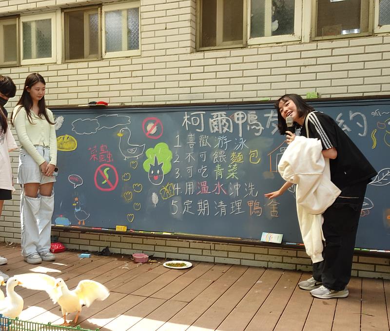 元智同學向國小孩童介紹柯爾鴨的友善公約，希望大家一同遵守