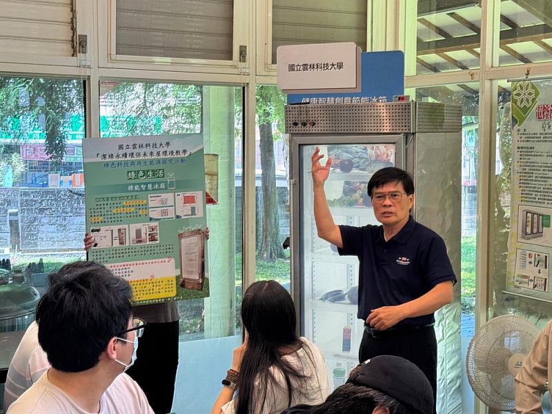 萬騰州教授介紹潔綠綠能屋展示的智慧節能冰箱,說明其能源管理設計與在綠色生活中的應用潛力。