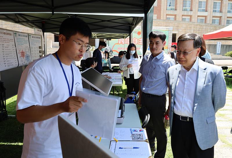 亞大校長蔡進發(右)，參觀資電學院攤位，了解「教育大數據微學程」。