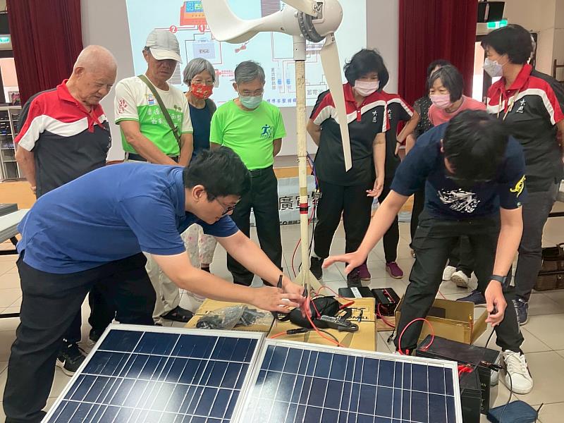 陳宥任老師與機械系學生向民眾示範風光互補發電架設。