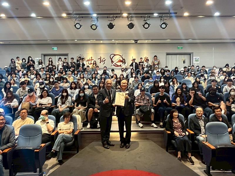 立法委員王世堅（右）蒞臨世新大學「通識講座」，由校長陳清河（左）代表致贈紀念品，與現場滿座師生合影留念。（世新大學提供）