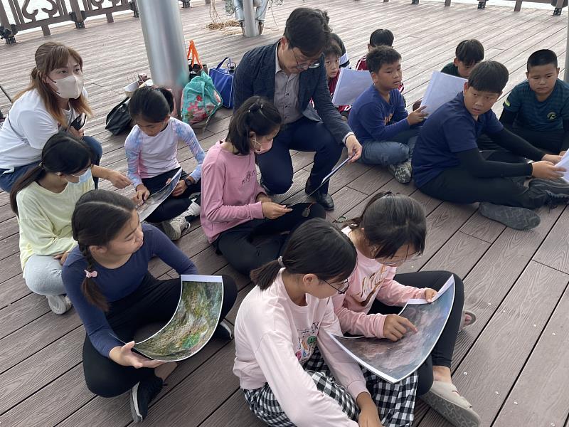 南安國小校長郭啟鴻與校內15名自願報名觀察活動的中高年級生，在下水前先於岸上進行準備，此為稍後水下珊瑚觀察的事前學習。
