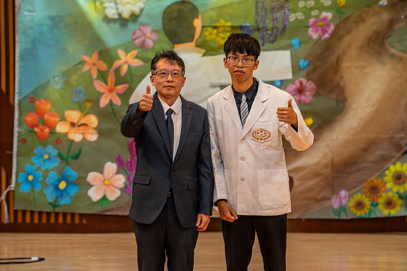 嘉藥校長張翊峰為學生代表陳煒翔披上白袍