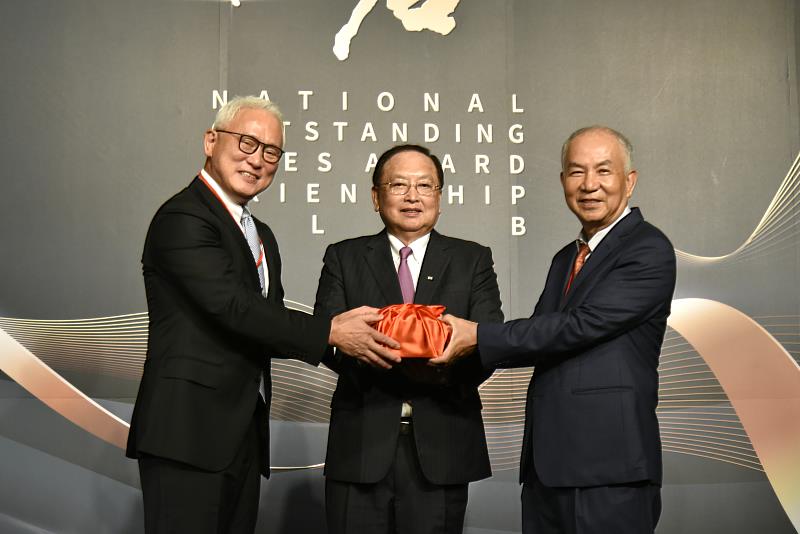由中小企業總會理事長李育家（中）監交，第14屆總會長可文山（左）將印信交接給第15屆總會長吳定國（右）