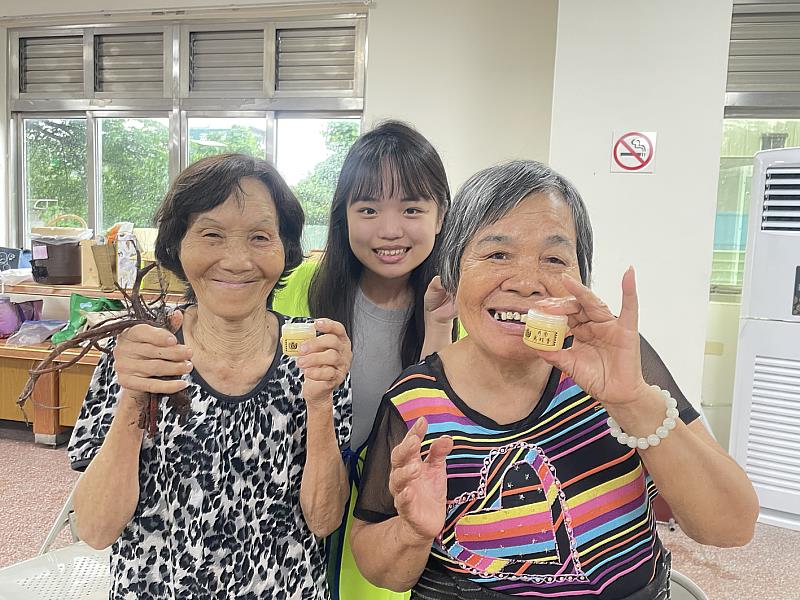 80歲楊阿嬤(左)開心在嘉藥學生協助下完成丹參萬金膏