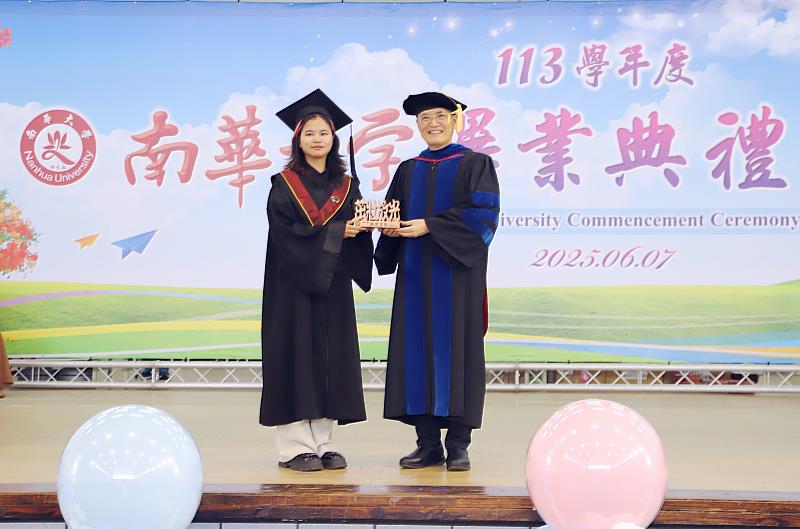 南華大學舉辦畢業典禮，畢聯會會長陳臆文(左)代表全體畢業生致贈「茁壯放光」紀念座予學校。