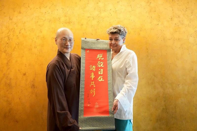 世界宗教博物館發展基金會執行長顯月法師（左）致贈創辦人心道法師「脫殼自在，諸事共好」卷軸給瓜地馬拉第一夫人貝娜多。（圖由世界宗教博物館提供）