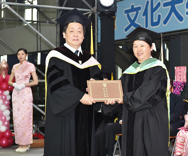 曾奪雅典奧運射箭銅牌,文大運動教練博士陳麗如畢業。王子奇校長(左)為陳麗如(右)正冠及頒授畢業證書。