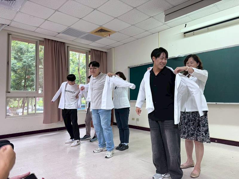 亞大保健系老師，為即將參加營養實習的同學披上白袍。