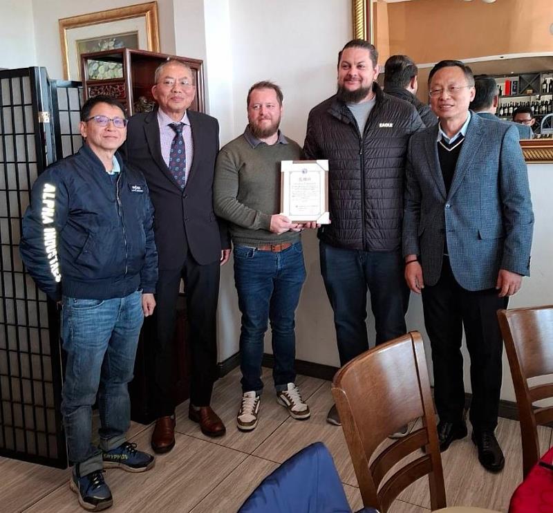廖大使（右一）與獲贈送感謝狀南非代理商（右二、三）合影，在場觀禮者有卓會長（左二）及經濟組羅組長（左一）。