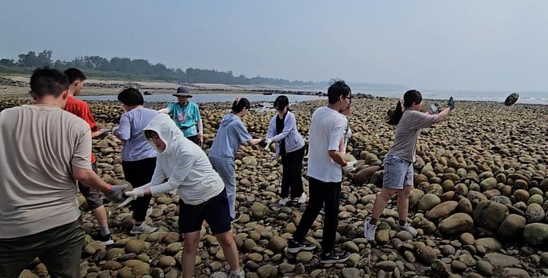 學生們透過「人力接龍」的方式親力親為搬運石塊構築石滬(照片/中國科大提供)
