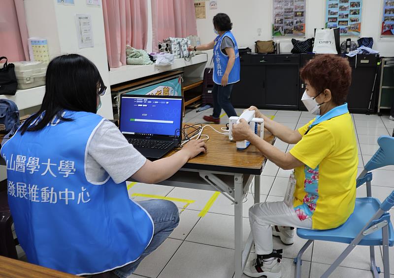 中山醫大USR團隊進入社區進行手部握力檢測，幫助長輩了解肌力狀況。