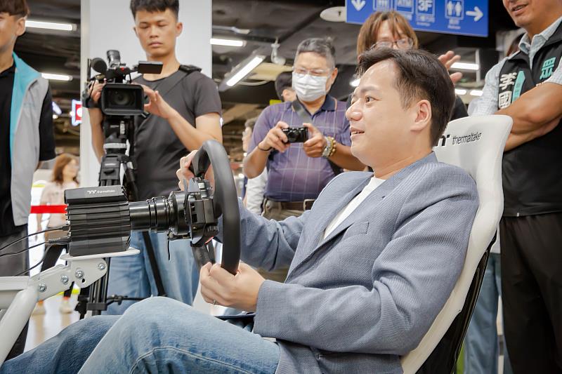 邱臣遠代理市長體驗虛擬賽車電玩。