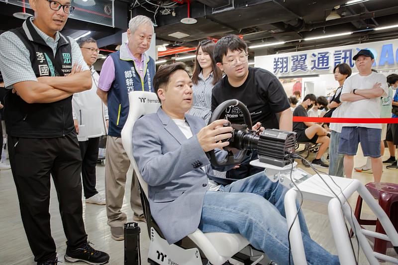 邱臣遠代理市長體驗虛擬賽車電玩。