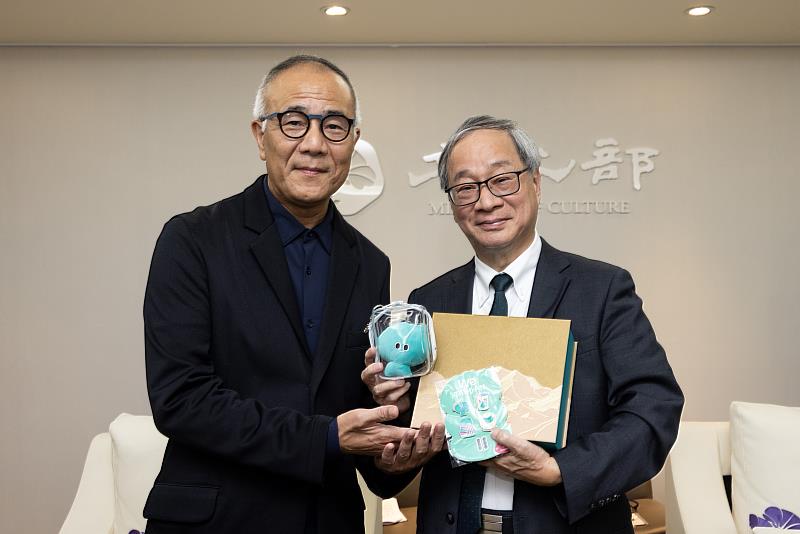 「雙小野」再度會面,文化部長李遠(右)贈送8月即將登場的「臺灣文化in大阪.關西世博」吉祥物「a-We」痛包及徽章等文宣品予橫濱市藝術文化振興財團業務執行理事小野晉司(左)。