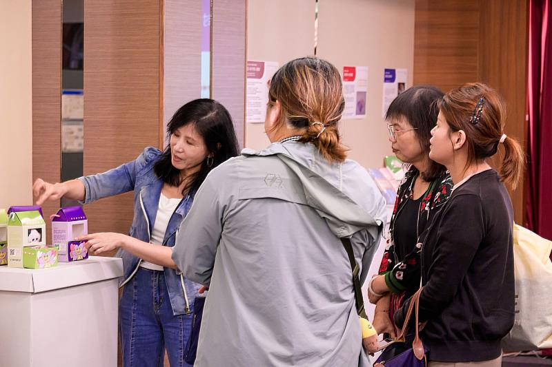 世新圖傳系助理教授陳秀真（左一）為社福單位介紹學生設計作品。（世新大學提供）