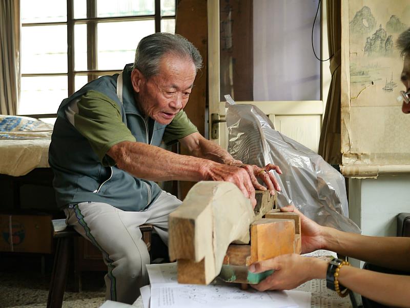 重要文化資產保存技術「大木作技術」保存者許漢珍於7月5日辭世,長期致力於傳統大木作技術,以及廟宇空間木作結網技術傳承,圖為其講解斗拱搭接方式。(成功大學建築系徐明福教授研究室提供)