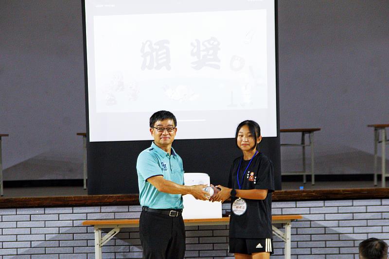 員林講堂與南華大學共推三好,兒童夏令營歡喜結營,南華大學體育處副處長黃孟立(左)頒獎給表現績優的學員。