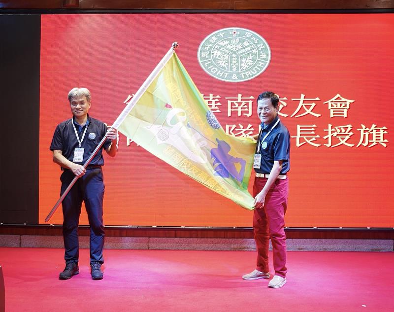 年會中進行高爾夫球隊隊旗交接，蔡慶南隊長（右）從王崇守會長（左）手中接下隊旗，象徵運動精神的薪火傳承。