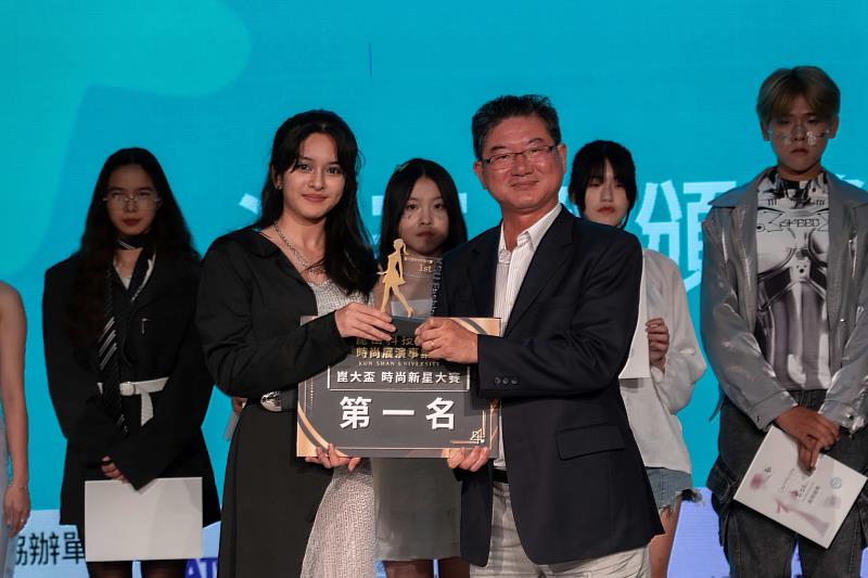 台灣流行時尚產業聯盟張慶鐘理事長(右)頒發第一名給華岡藝校表藝科英家綺(左)