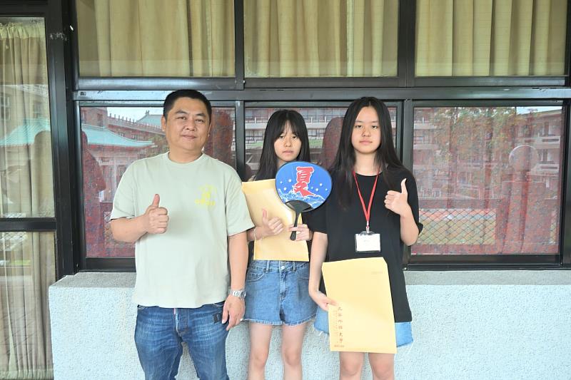 雙胞胎姊妹楊毓丞(中)與楊筑宇(右)，在父親陪同下前來撕榜，分別錄取日本語文科與法國語文科。
