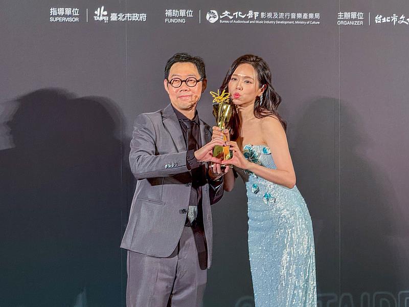 世新廣電系校友林書宇(左)榮獲最佳編劇,由妻子夏于喬(右)頒獎。(世新大學提供)