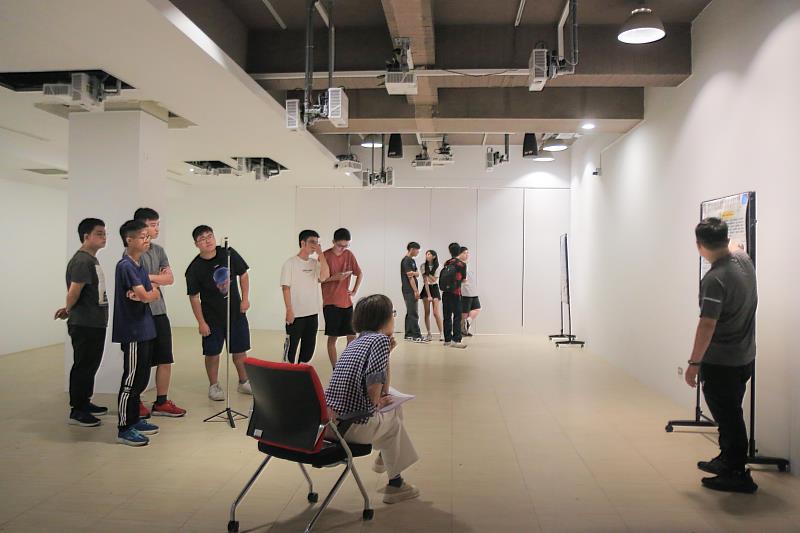 南臺科大學生於展場進行海報內容講解並錄製影片之情形。