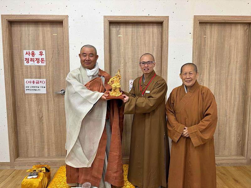 江華島普門寺住持禪照法師(左)與知賢法師(中)相見歡，台韓佛門交流友好互贈觀世音菩薩聖像。